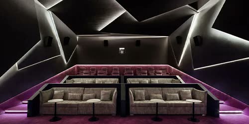 Bordo tonlu ev sinemasi salonunda kirik-cizgili (origami) akustik duvar/tavan kaplamasi, sinema koltuklari, insan yok
