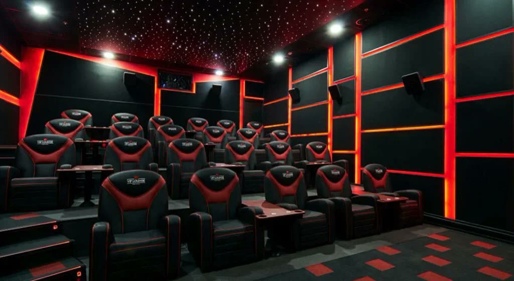 Kırmızı-siyah temalı özel sinema salonu, akustik panelli duvarlar, koltuk sıraları, yıldızlı tavan aydınlatması